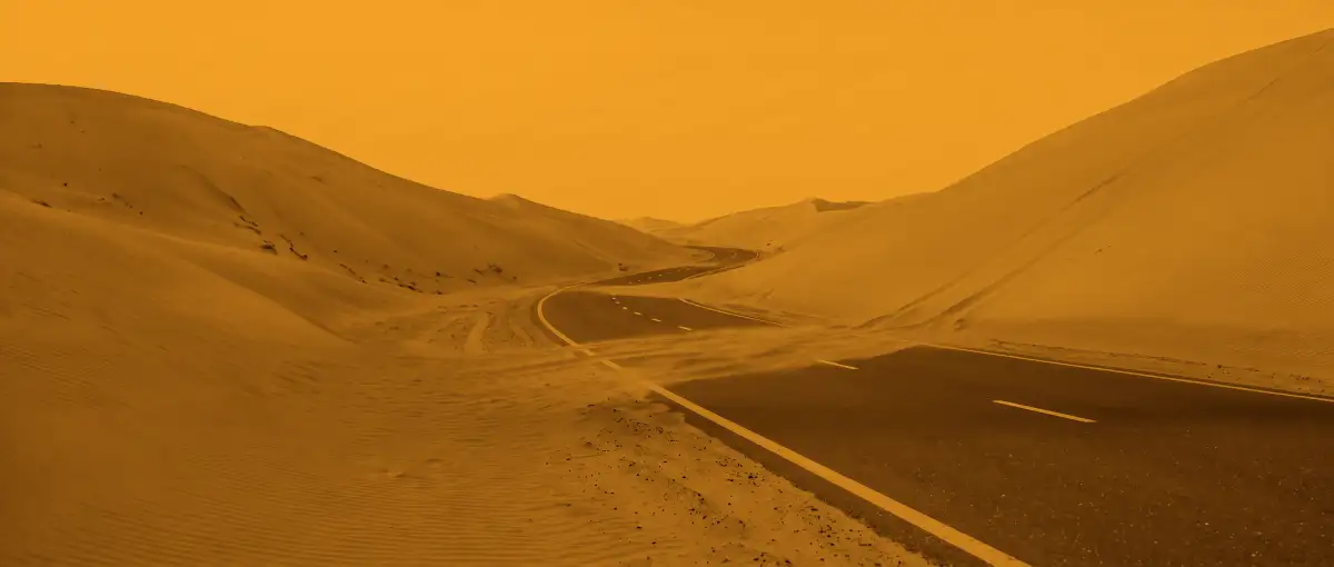 The same desert road in the amber light of the lit rev counter
